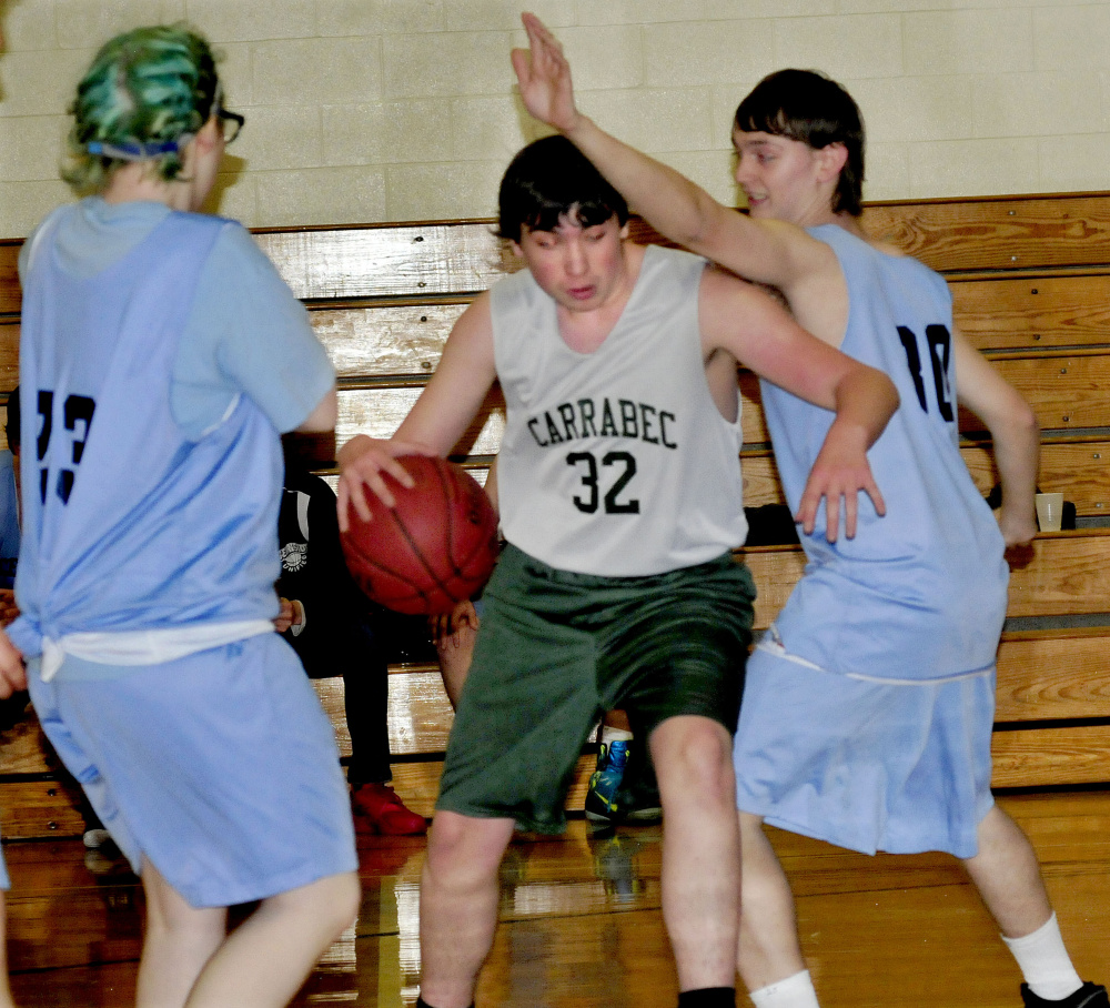 Carrabec/Madison's Roger Pickard drives between two Oceanside defenders during a unified basketball North quarterfinal Wednesday afternoon in North Anson.