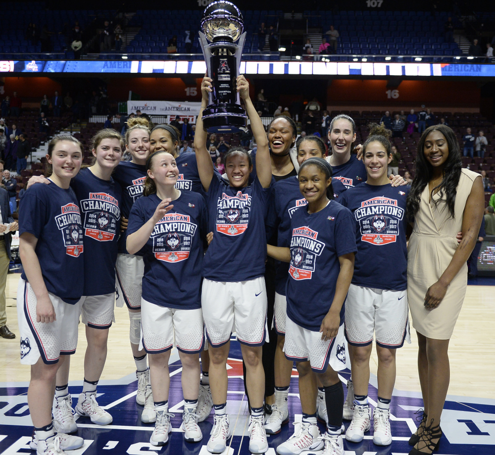 The Connecticut women's basketball team pose with the American Athletic Conference championship trophy after defeating South Florida on March 6 in Uncasville, Connecticut.