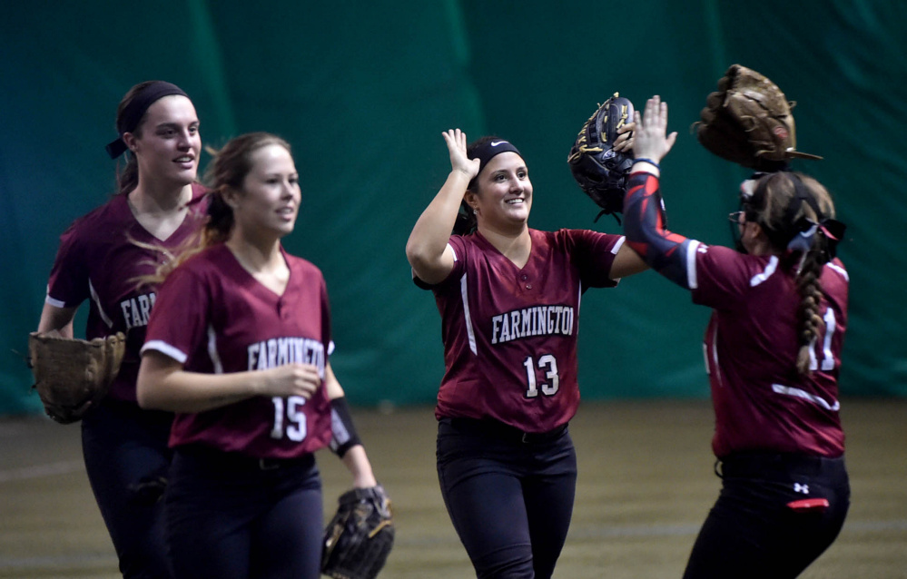 University of Maine Farmington center fielder Kiana Thompson (13) celebrates with teammates after beating the University of Maine at Presque Isle on Saturday at the Sport Dome in Topsham.