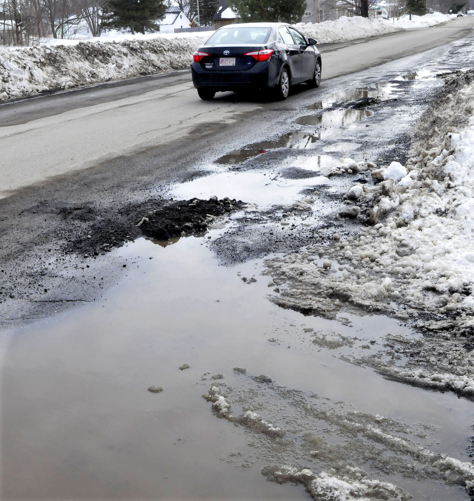 One side of the Greenwood Road in Skowhegan is full of potholes Thursday.