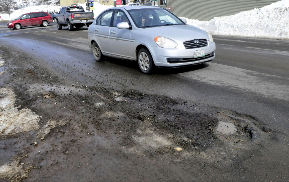 Traffic in Skowhegan tries to avoid running over the potholes on one side of Main Street on Thursday.