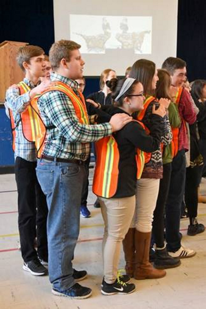 As part of the "Build a Bridge, Love Your Neighbor" middle school rally at St. Michael School in Augusta, members of the Catholic Youth Leadership Team, composed of teen leaders from around Maine, wear reflective vests to symbolize construction workers who build bridges.