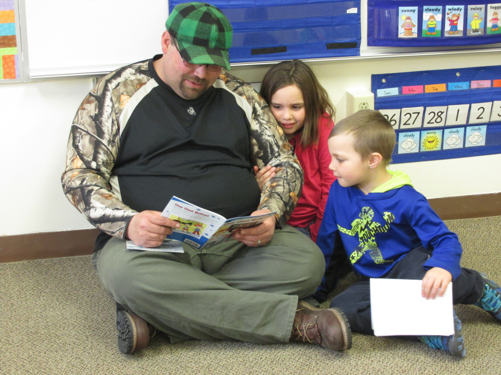 Eugene Worster read with his children, Remington and Melynda, during Dr. Seuss Day on March 2 at Forest Hill Elementary School in Jackman.