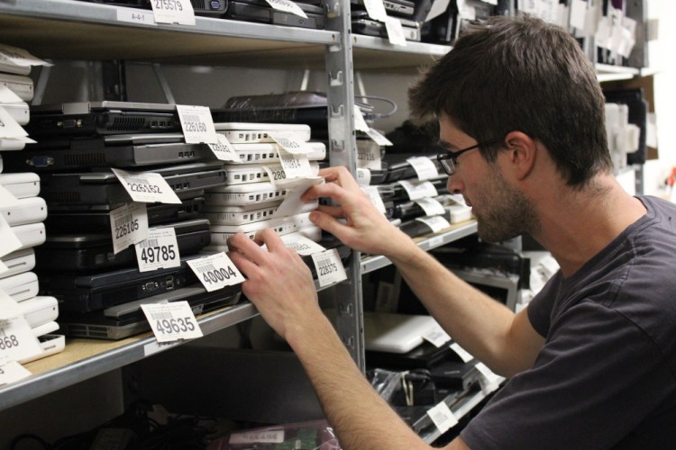 GoodTech employee Eric Landau looks through stacks of laptops in this undated photo from the agency.