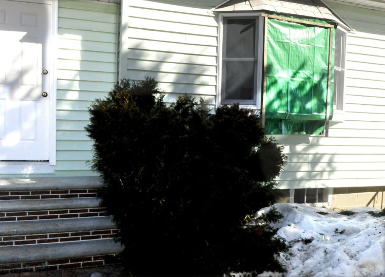 A tarpaulin covers a broken front window March 13 at the Audrey Hewett residence at 47 Lyons Road in Sidney. Police say Dreaquan Foster, 21, of Rhode Island, was shot in the chest there by Hewett's son after a fight.