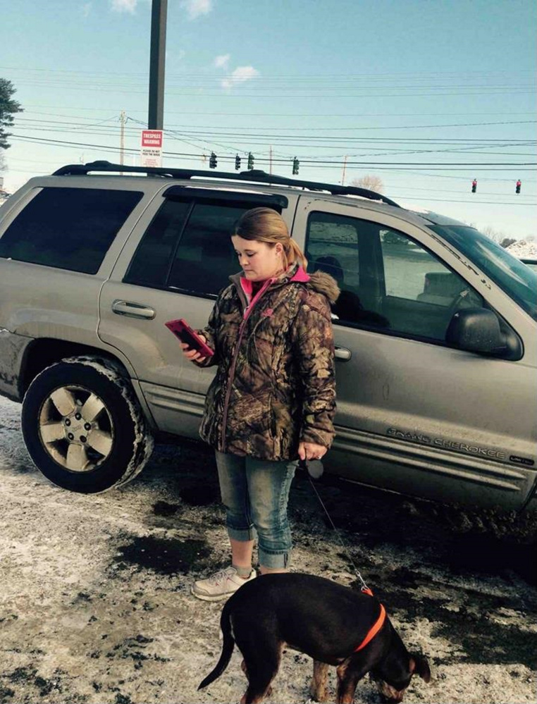Nicole Bizier, 32, stands by her silver Jeep in the Pizza Hut parking lot with the dog she tried to sell to state animal welfare agents and Skowhegan police on Feb. 2.