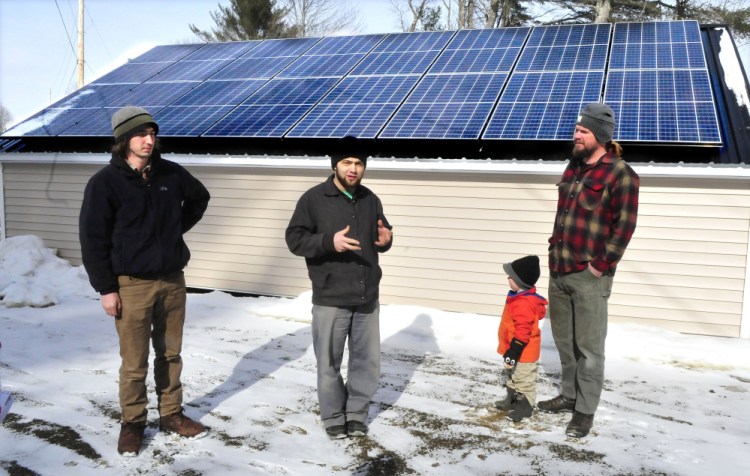 Joas Hochstetler, center, manager at Backyard Buildings in Unity, talks about the shed built at the Unity shop on Wednesday. At right is Matt Wagner, project manager for Insource Renewables, and his son, Ansel. Insource employee Ben Holt is at left.