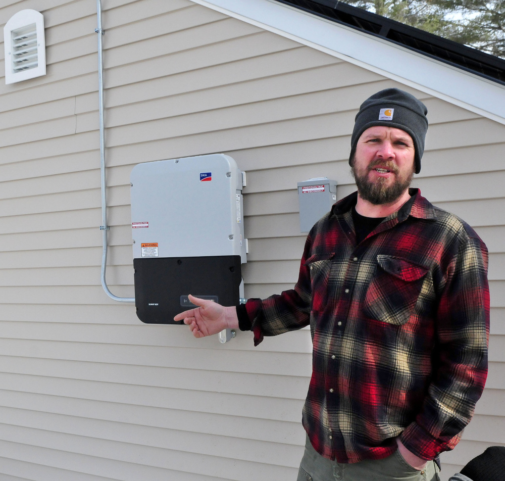 Matt Wagner of Insource Renewables in Pittsfield explains the process of an inverter that converts direct current energy to alternating current energy on a Backyard Buildings shed with solar panels in Unity on Wednesday.