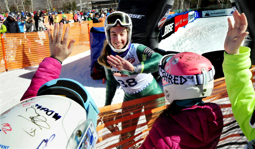 Carrabassett Valley Academy graduate Amelia Rowland signs autographs and gives high- fives to fans after competing in the second run of the women's slalom races during the U.S. Alpine Championships on Sunday at Sugarloaf.