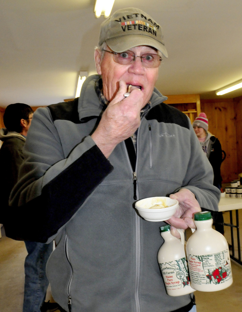 Holding two quarts of fresh maple syrup, Alfred Labonte samples syrup poured over ice cream at Strawberry Hill Farm in Skowhegan on Maine Maple Sunday. "I have to do this event every year," Labonte said.