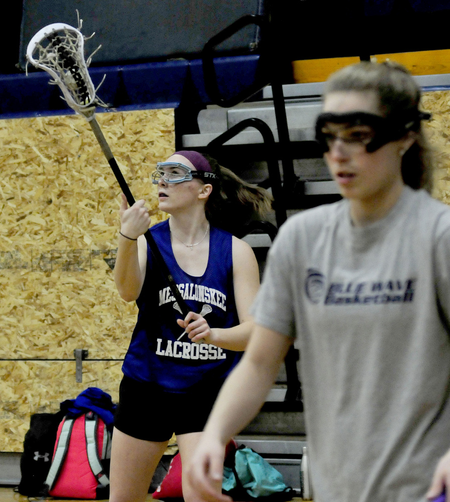 Messalonskee girls lacrosse player Autumn Littlefield, left, catches ball as teammate Sophie Holmes participates in a drill during practice Wednesday at the high school.