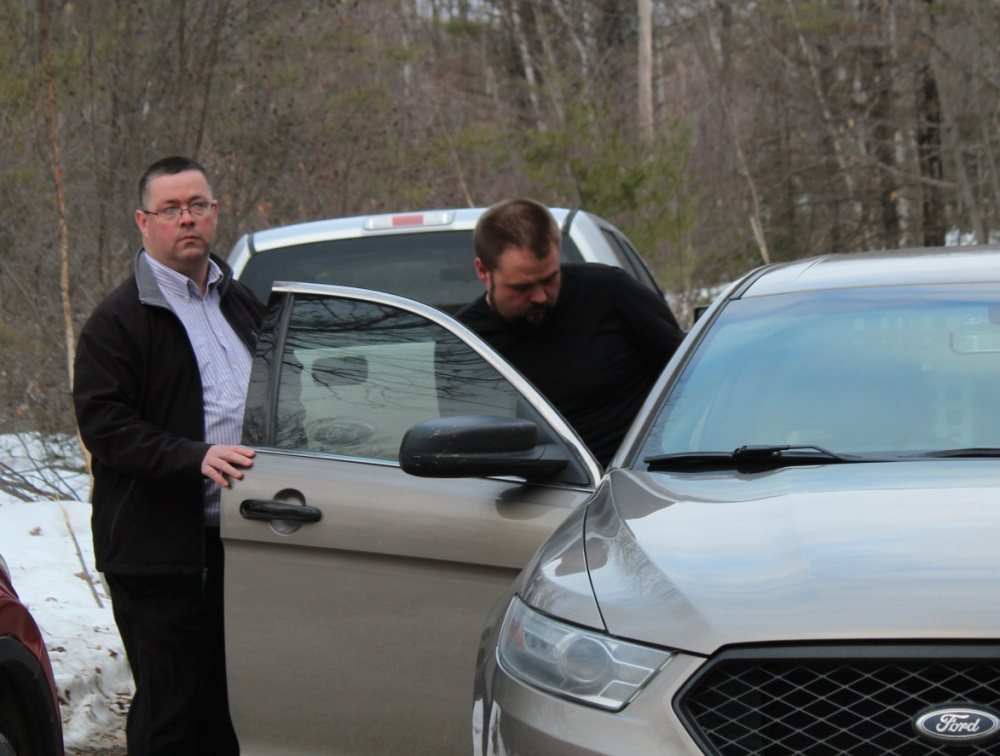 State police Sgt. Christopher Tupper puts Jared Moody into a cruiser Wednesday after Moody's arrest on a child pornography charge.