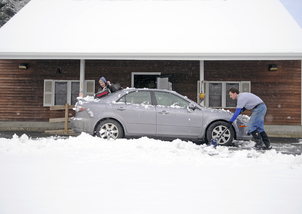 Justin Underwood, right, and Michael Giroux dig out from a snowstorm on April 9, 2015, at Underwood's business, Hallowell Seafood and Produce. An April Fool's Day storm is forecast to blanket the region Saturday.