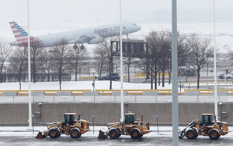 An American Airlines jet departs during the snowstorm at O'Hare International Airport in Chicago on Monday. Some areas received up to 5 inches of snow, and more than 400 flights were canceled at O'Hare. 