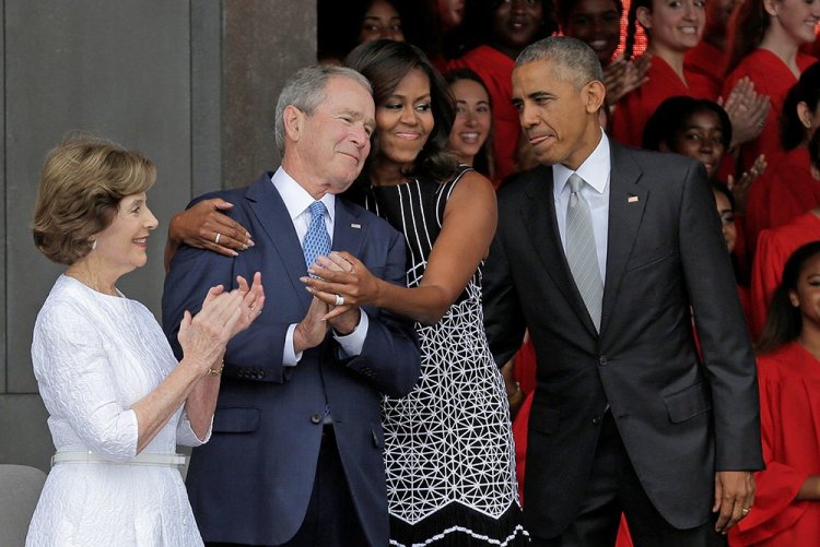 Michelle Obama hugs former President George W. Bush as she arrives with President  Obama and former first lady Laura Bush for the dedication of the Smithsonian's National Museum of African American History and Culture in Washington on Sept. 24, 2016.           