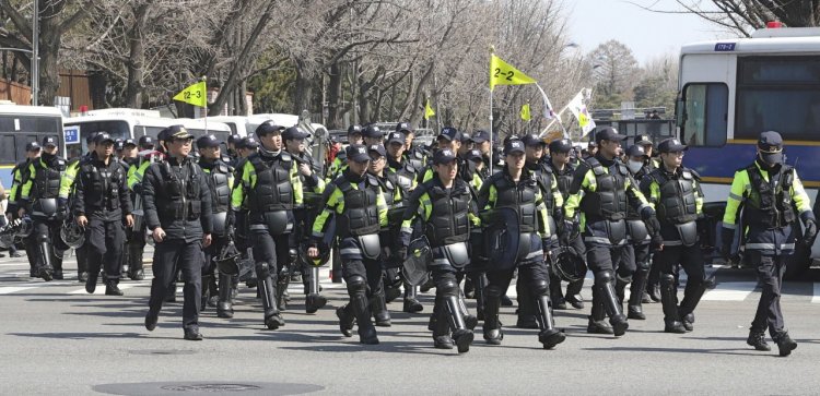Police officers move near the presidential Blue House in Seoul, South Korea, Friday. South Korea's Constitutional Court formally removed President Park Geun-hye from office over a corruption scandal that has plunged the country into political turmoil and worsened an already-serious national divide. 