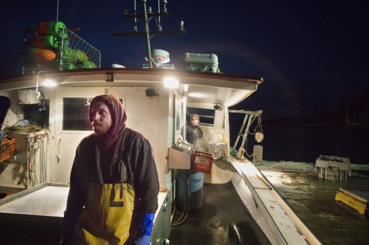 Joshua Kane, foreground, and Mark Pinkham offload lobster while docked at Cranberry Isles Fishermen's Co-Op on Little Cranberry Island. Kane, a 32-year-old lobster-fishing apprentice, is a former opioid addict who encourages other fishermen to seek treatment and talks openly about his own addictions. Staff photo by Gregory Rec