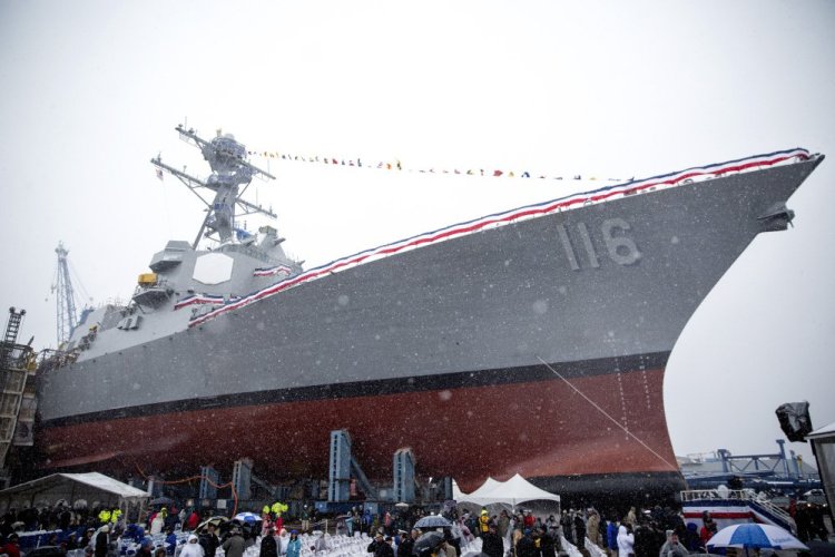The future USS Thomas Hudner towers over the crowd at its christening ceremony at Bath Iron Works in April 2017. 