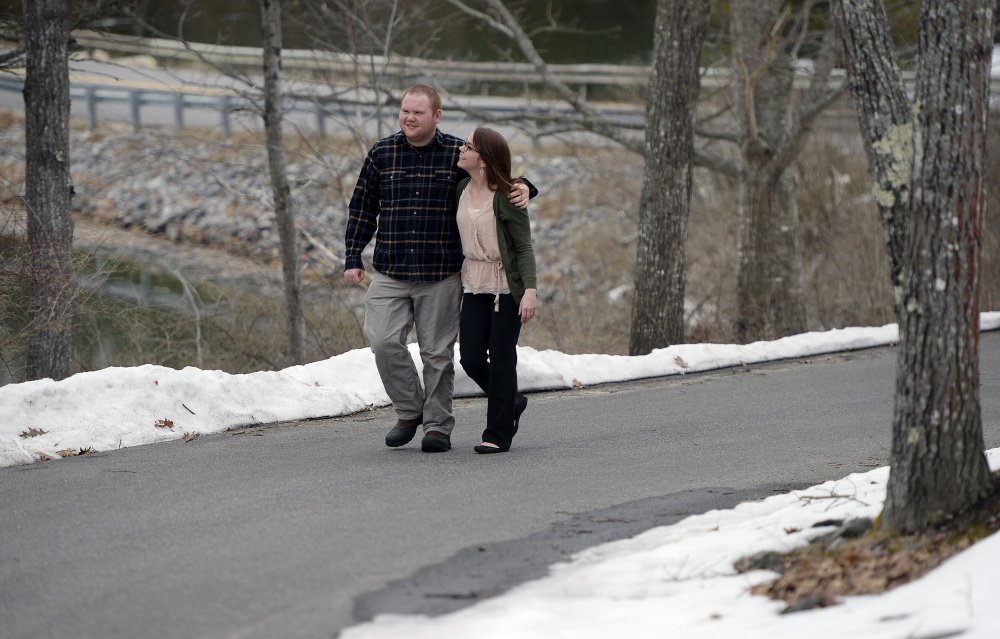 Kelsey Dunn and her brother Silas Gingrow walk near Gingrow's group home in Bath. Dunn works in human resources for the Independence Association, which runs group homes in the Brunswick area. Low MaineCare reimbursement rates have made it a nightmare for the homes to find workers, Dunn says.