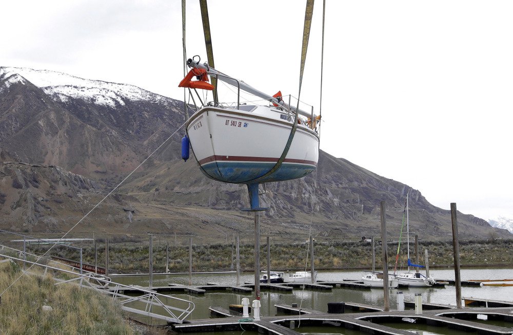 A beached sailboat is hoisted into Utah's Great Salt Lake on Thursday, about 20 miles west of Salt Lake City.