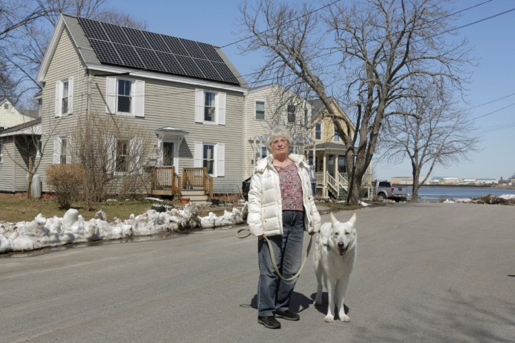 City Councilor Susan Henderson stands with her dog Jake outside her home on E Street in South Portland. 