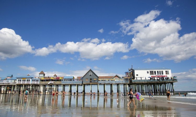 Beachgoers walk by the Old Orchard Beach Pier last summer. This popular tourist destination for generations of Canadians doesn't appear to be suffering from what industry experts predicted would be a "Trump slump."