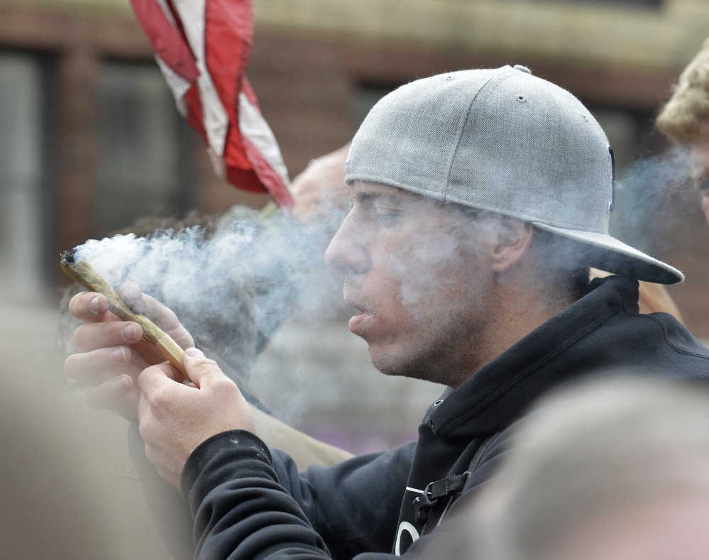 ABOVE: Justin Adgateo of Boston partakes of a monstrous 8-gram joint that was making its way through the crowd that gathered Thursday around marijuana advocate and writer Crash Barry, who was giving away free samples in Monument Square.