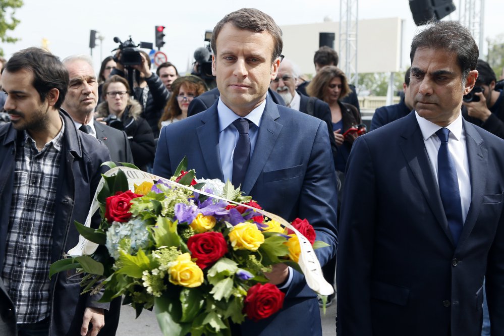 Presidential candidate Emmanuel Macron, center, next to Mourad Franck Papazian, co-president of France's Armenian Organizations Coordination Council, prepares to lay a wreath marking the 102nd anniversary of the slaying of Armenians by Ottoman Turks.
