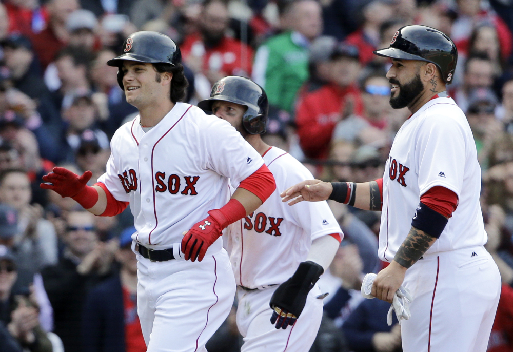 Boston Red Sox left fielder Andrew Benintendi, left, celebrates his three-run homer with teammates Dustin Pedroia, partially hidden, and Sandy Leon, right, in the fifth inning Monday against the Pirates in Boston.