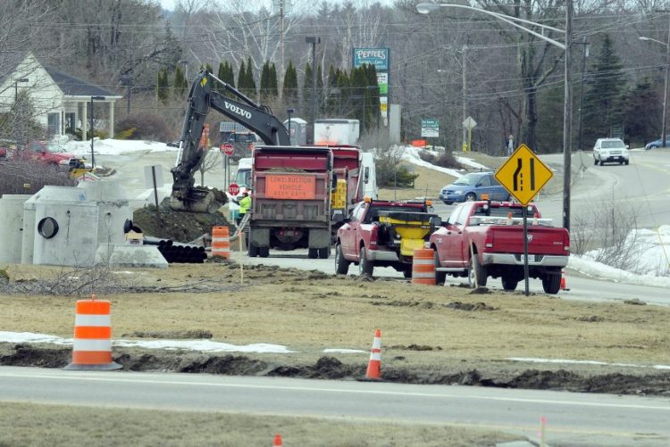 Construction workers dig up the intersection of Main Street and U.S. Route 202 on Wednesday in Winthrop.