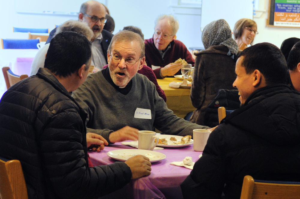 Adnan Kadhim, left, the Rev. Frank Morin, and Hassan Nasar chat over lunch on Saturday at Prince of Peach Lutheran Church in Augusta during a meeting to discuss creating a community center to welcome new residents.