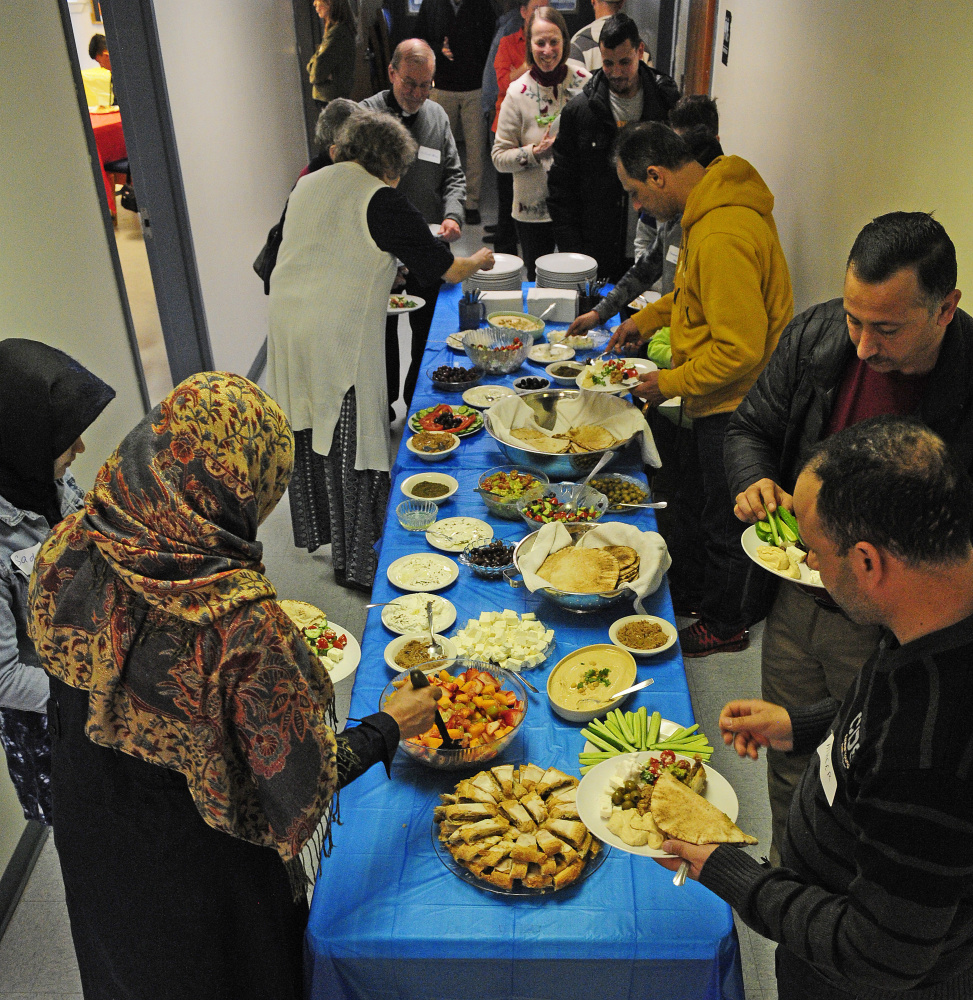 People serve themselves lunch from the buffet table on Saturday during a meeting at Prince of Peach Lutheran Church in Augusta to discuss creating a community center to welcome new residents.