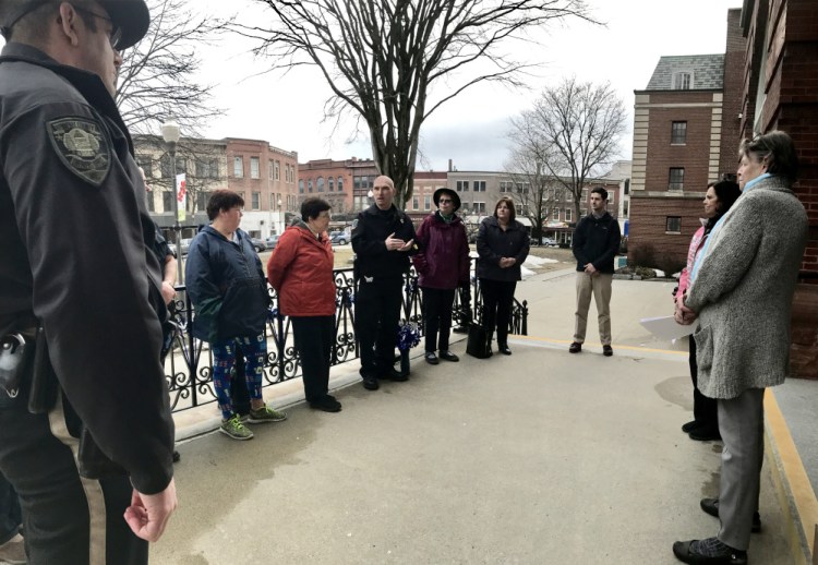 Bill Bonney, deputy chief of Waterville Police, center, speaks to about a dozen people who turned out Wednesday evening on the steps of Waterville City Hall to mark Child Abuse & Neglect Prevention Month.