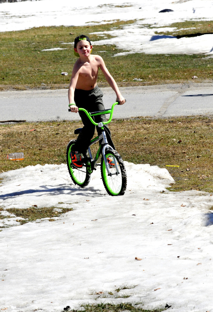 It was warm enough on Sunday for Camren Foster to ride his bike without a shirt on in Waterville, but he soon found that riding through snow is not so easy. Asked how he liked the spring weather, Foster said, "Good, no, perfect."