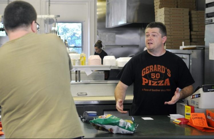 Gerard's Pizza proprietor Jeff McCormick speaks with customer Ben Tracy, of Gardiner, on Aug. 10, 2015, at the counter of the Gardiner restaurant. Gerard's opened that day after closing because of a fire on July 16 in neighboring buildings. Jeff McCormick died Saturday at the age of 43.