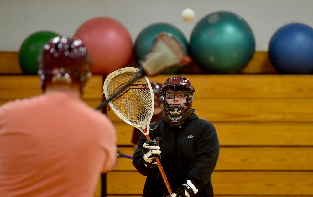 Senior Kollin Cobb, facing, plays pass with teammate Sam Goodsoe, left, during the first practice for the combined Nokomis and Maine Central Institute lacrosse team Tuesday at Maine Central Institute in Pittsfield.