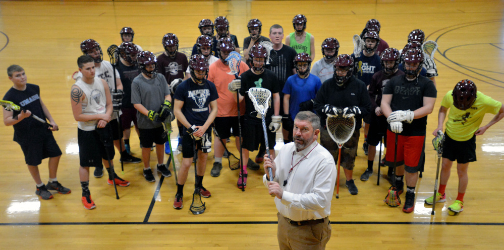 Chris Hopkins, head coach of the combined Maine Central Institute and Nokomis boys lacrosse team, poses with his players this week in Pittsfield.