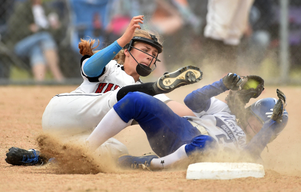 Heads up: Hall-Dale shortstop Alyssa Bonenfant, left, tags out Madison runner Ashley Emery at second base during a Class C South semifinal game last season in Madison.
