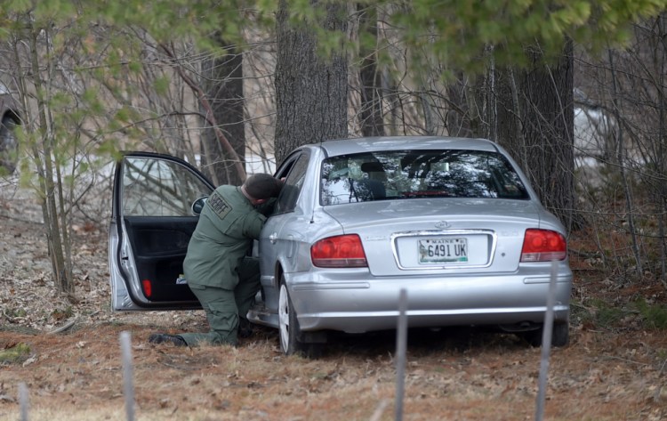 Detective Sgt. Scott Mills, of the Kennebec County Sheriff's Office, investigates a car crash Thursday on Mayflower Hill Drive at Colby College in Waterville. The driver, Donovan M. Gray. 68. died later in a hospital.