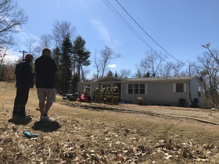 Enos Webster Jr., right, stands outside his mobile home at 1351 South Clary Road after a fire started in his bathroom Monday afternoon. Webster tried to put the fire out himself, but soon had to call firefighters to the scene.