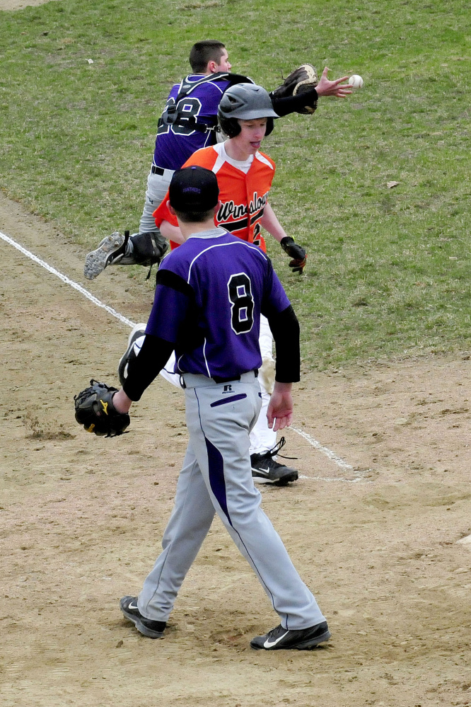 Waterville catcher Daniel Gaunce catches the ball as Winslow's Tom Tibbetts crosses home plate and Waterville pitcher Cody Pellerin (8) backs up the play Wednesday in Waterville.