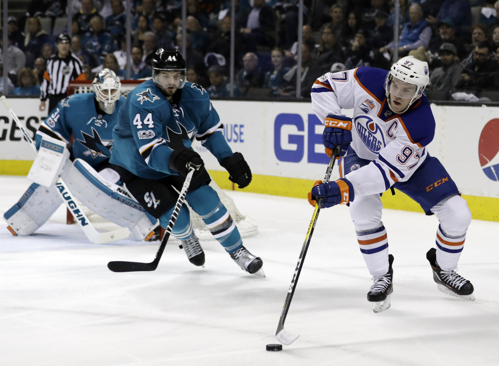 Edmonton Oilers phenom Connor McDavid (97) reaches for the puck next to San Jose Sharks' Marc-Edouard Vlasic (44) during the second period of Game 4 on Tuesday.