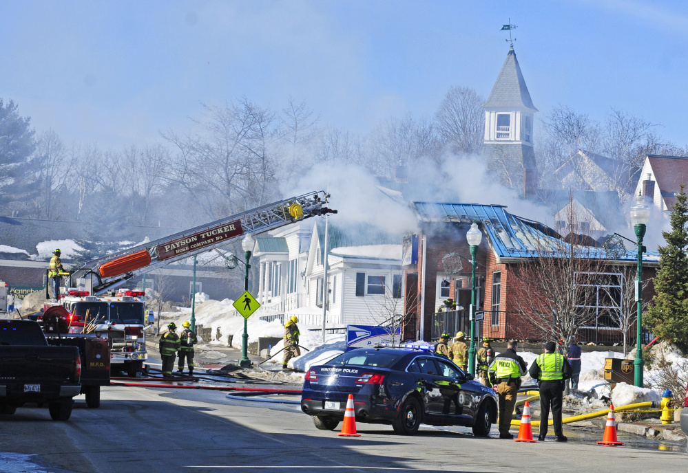 Firefighters work on Feb. 21 at the post office in Winthrop, which was destroyed by fire.