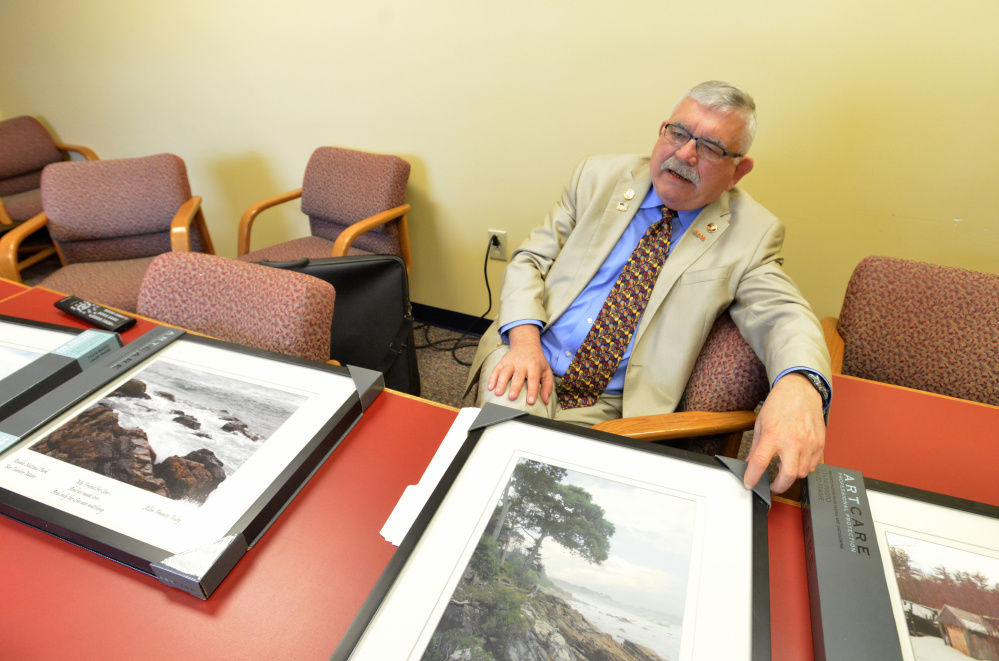 Allen Francis Foley sits Tuesday with a selection of his photographs that he shoots and sells, with 30 percent of the sale proceeds going to Homeless Maine Veterans and 10 percent to the Children's Christmas Fund.