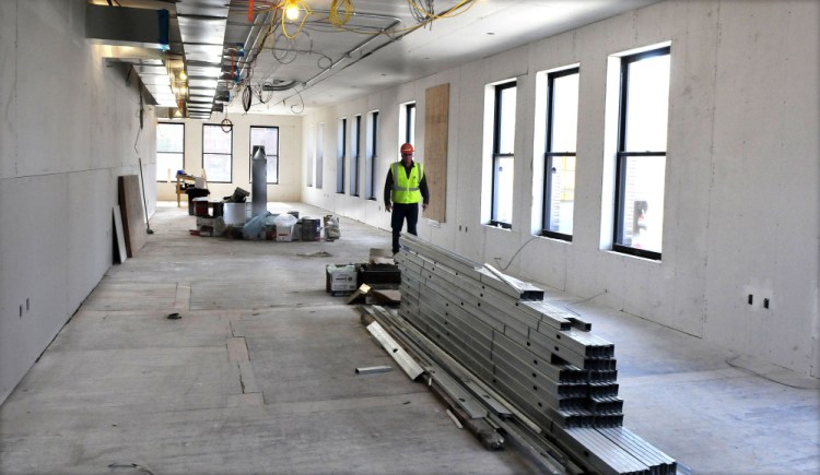 Ken Theriault, superintendent of P.C. Construction, walks past new windows and construction of new space on the second floor of the former Hains building in downtown Waterville on Monday.