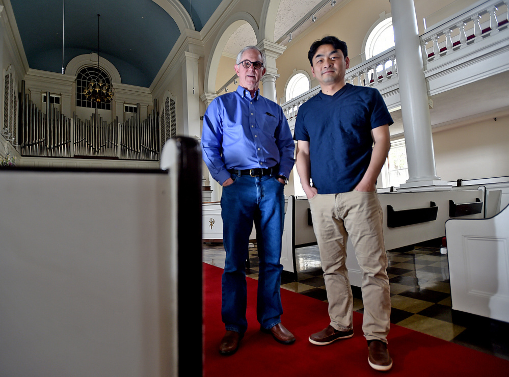 Jonathan Hailstrom, left, music professor and former conductor at Colby College, stands on Tuesday with Jinwook Park, right, current Colby College Symphony Orchestra conductor at Lorimer Chapel at Colby College in Waterville. Hailstrom said the orchestra's finale has been planned for weeks to honor Peter Ré. Park will conduct the concerts' selections.