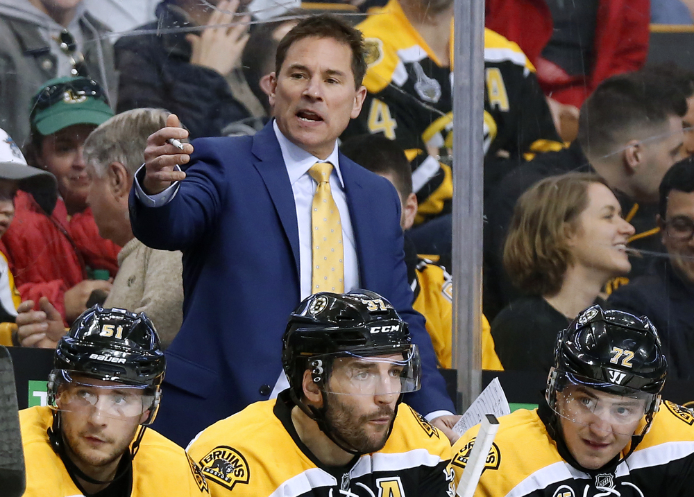 Boston Bruins interim head coach Bruce Cassidy works behind the bench in the third period of an April 8 game against the Washington Capitals. The Bruins said on Wednesday it will drop the interim tag and Cassidy will return next season as the team's head coach.