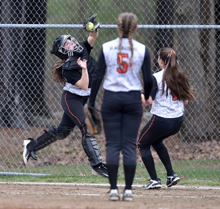 Winslow catcher Cassie Demers, left, makes a catch on a foul ball against Nokomis on Thursday in Winslow.