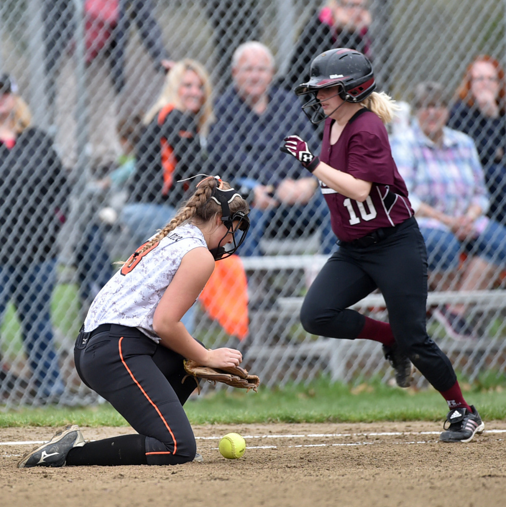 Winslow first baseman Natalie Greene, left, comes of the bag to reel in an errant throw as Nokomis' Hanna Meservey (10) reaches safely Thursday in Winslow.