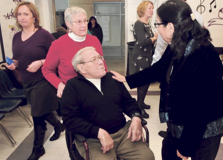 Joan Phillips-Sandy, right, congratulates retiring Waterville School Board member and chairman Lionel Cabana during an event honoring him Dec. 8, 2014. Behind Lionel is his wife, Judy, and at left is Susan Reisert who filled the Ward 2 board member position.